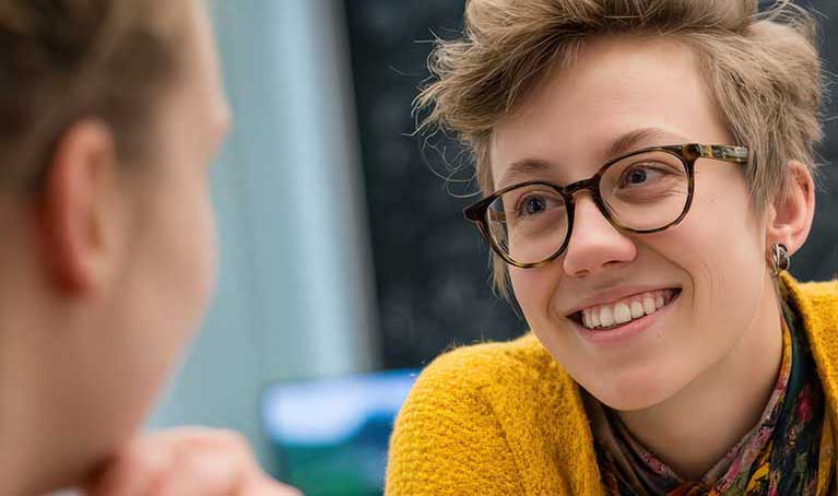 Close up of woman wearing glasses smiling in a conversation