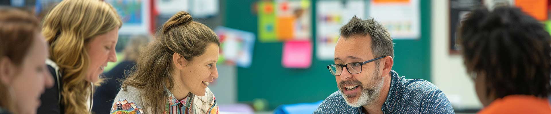 A group of teachers sitting in a classroom