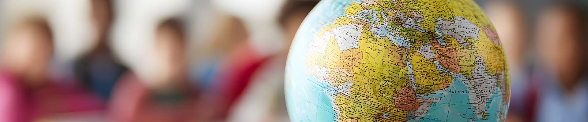 A globe on a table with a classroom in the background.