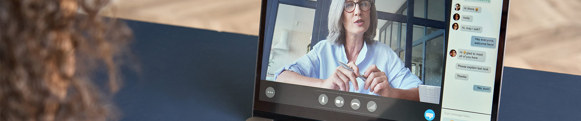 A person with curly hair watching online training on a laptop.