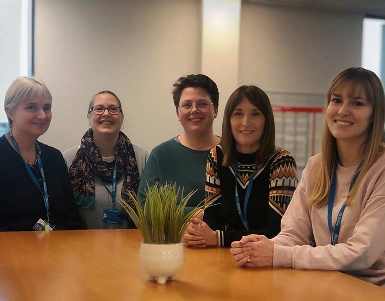 Group of people stood together smiling