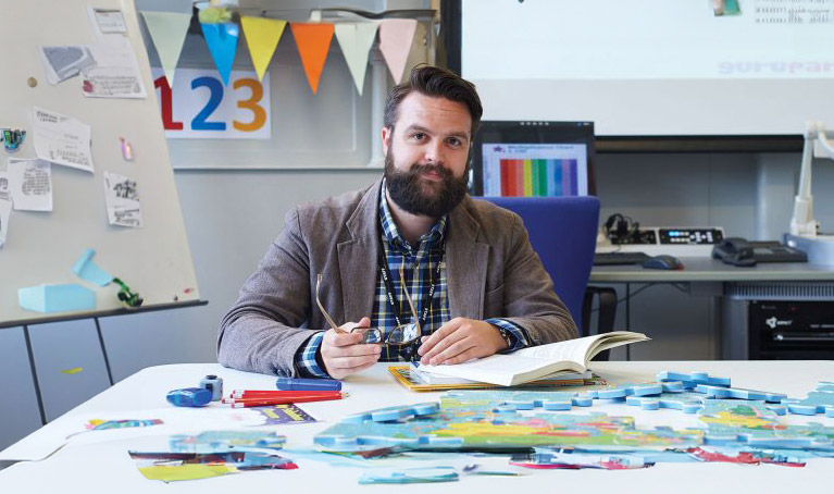 A teacher sat in a classroom at a table