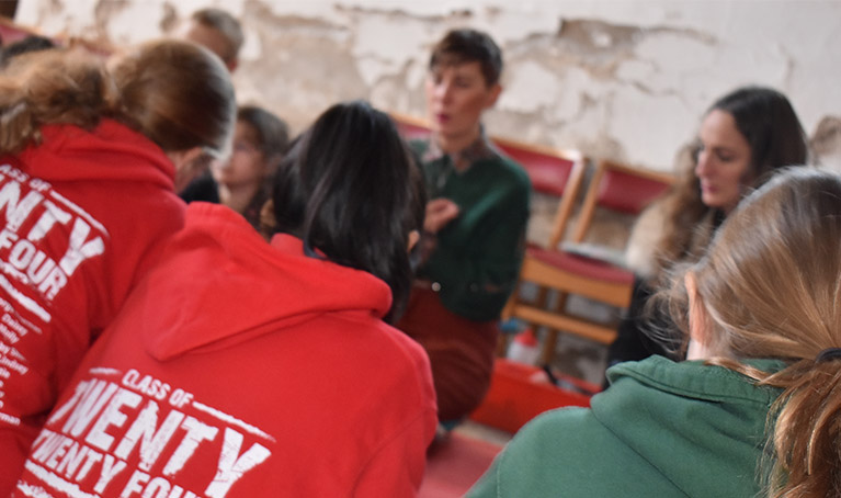 Emily and Andrea teaching students who are all wearing class of 2024 hoodies.