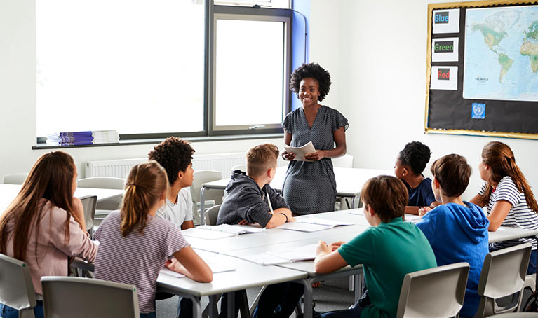A classroom of students and a teacher stood up