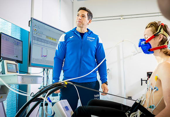 Postgraduate sports science research with a student being tested with heart monitors and an oxygen mask.