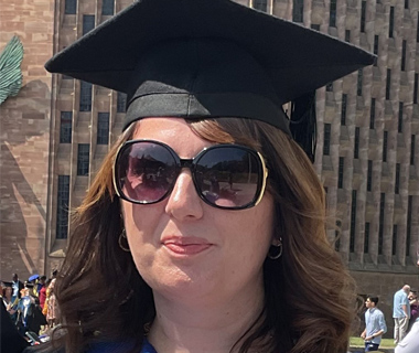 Portrait of Rebecca at her graduation wearing a graduation cap and gown.