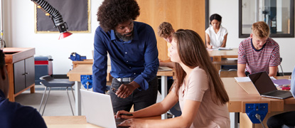 A teacher helping a high school student in class