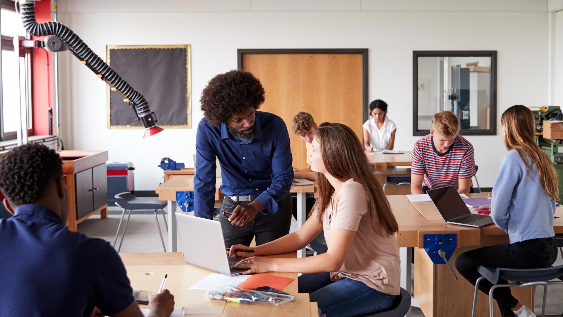 A teacher helping an older student in class.