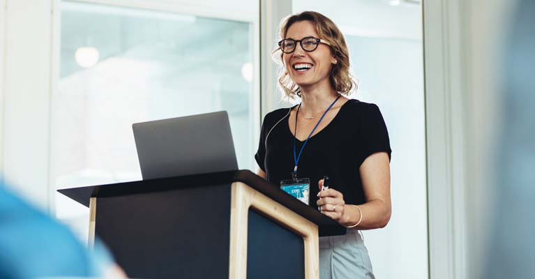 Female stood at a stand delivering a presentation