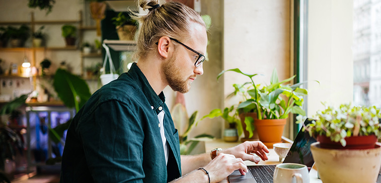 Man sitting down studying at a table.