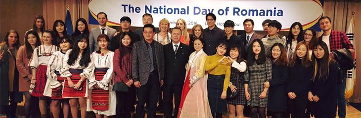 group photograph inside with a sign of The National Day of Romania behind