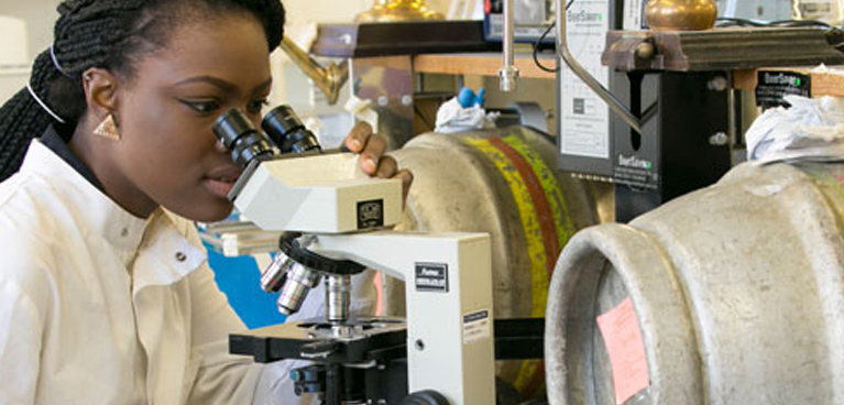 student in a laboratory looking through a telescope 