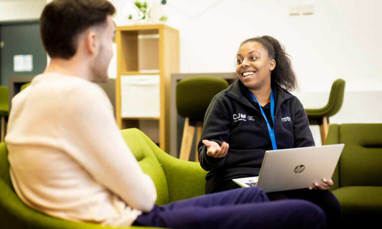 Professional services staff sat talking with a student