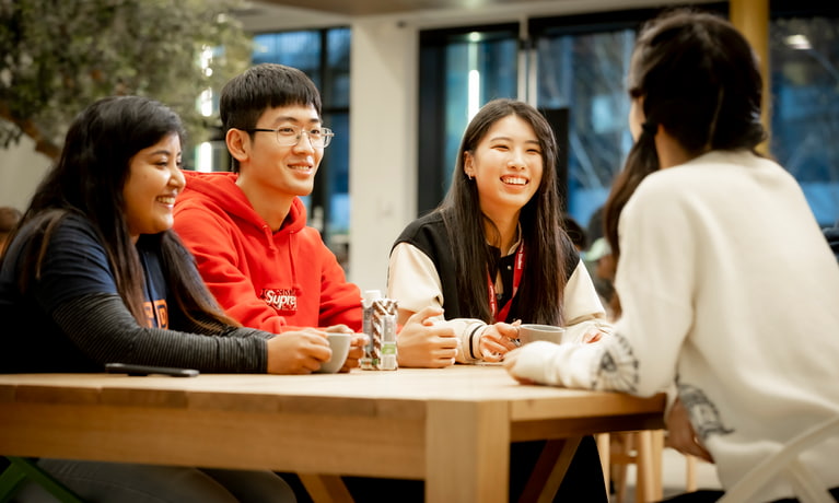 Four students sat at a table talking