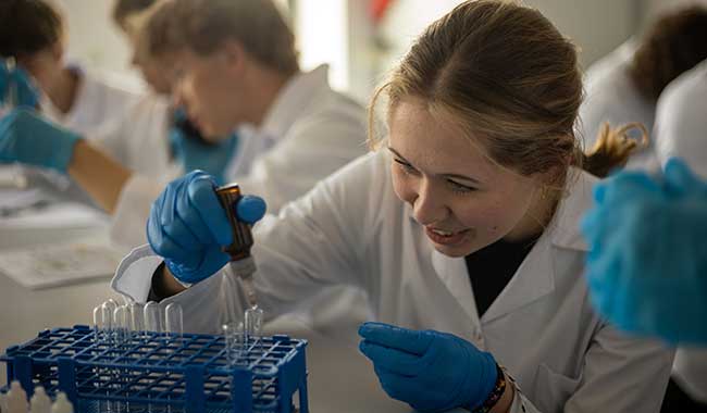 A student at Coventry University Wrocław working in the biosciences lab