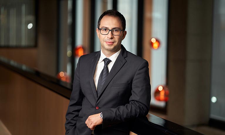 Man in business suit leaning against balcony